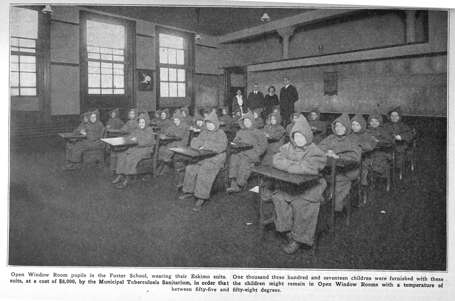 Students pose in an open air classroom wearing coats provided to help with the cold.